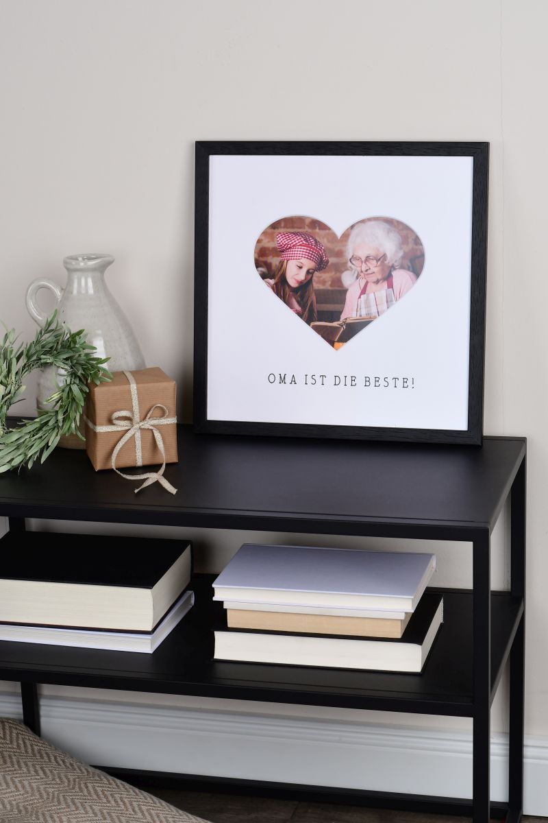 Marco de fotos negro 30x30 con recorte de corazón para la abuela en un ambiente hogareño